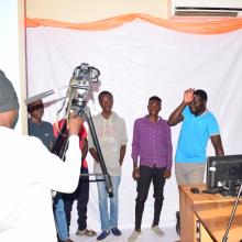 A group of youth testing out cameras in the library.