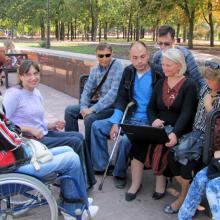 Group of trainees, some in wheelchairs, in the park.