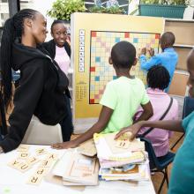 Children playing giant scrabble on a board in the library.