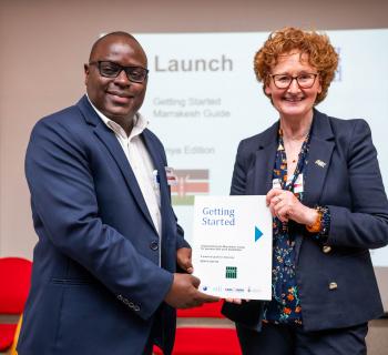 Dick Kawooya and Teresa Hackett holding EIFL's 'Getting Started' guide to the Marrakesh Treaty.