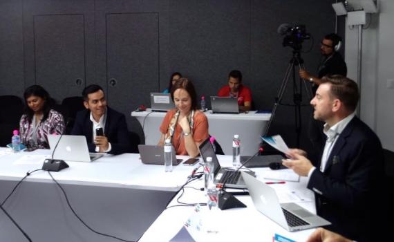 people addressing a panel discussion, at a table