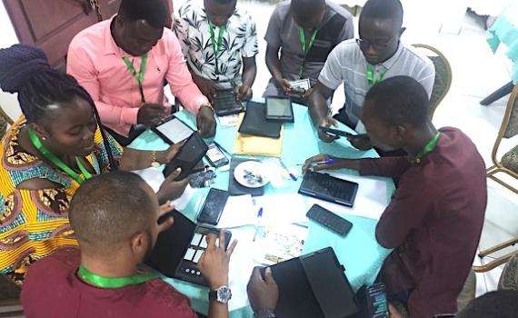 Group of public librarians with tablets, sitting around a table, during a workshop.