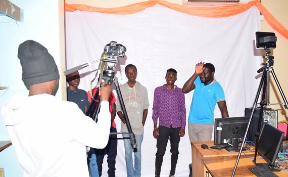 A group of youth testing out cameras in the library.