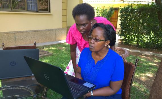 two sitting outside with computers